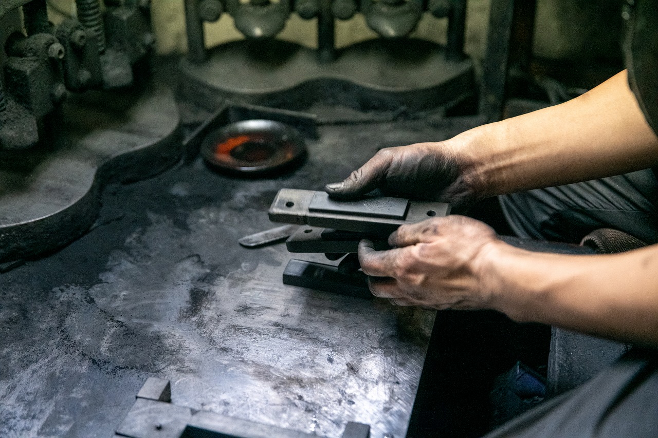 墨を型にはめる職人の手